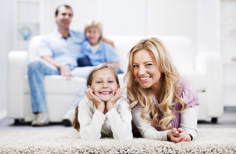 family laying on carpet and couch